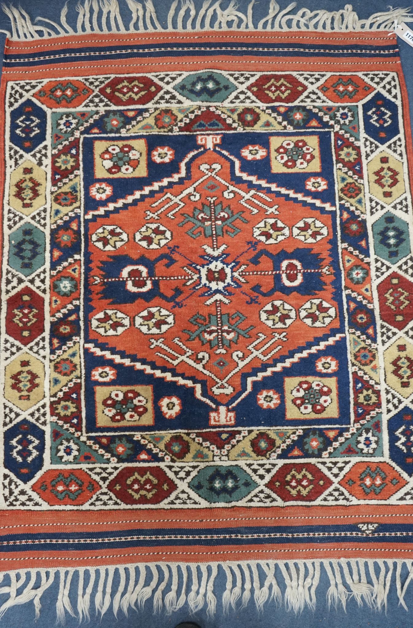 A Caucasian red ground mat, 120 x 95cm
